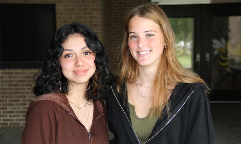 Two students smile